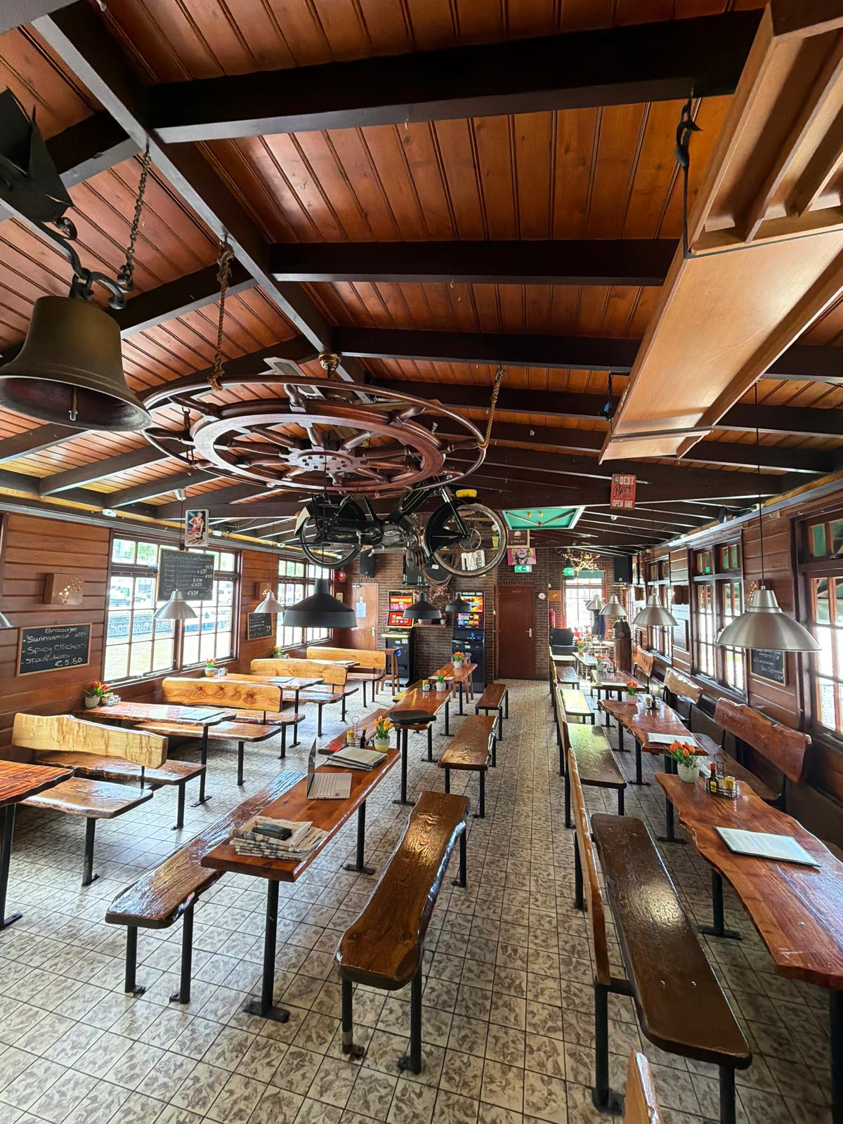 Interieur Koffiehuis De Laak — houten banken, stuurwiel, scheepsbel